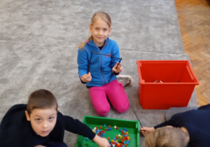 Uczniowie bawią się na dywanie