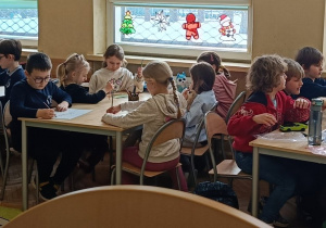 Dzieci przy stolikach wykonują ćwiczenie mapa myśli