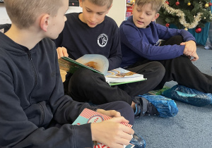 Chłopcy siedzą na dywanie