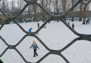 Uczniowie bawią się w zimowe zabawy na podwórku