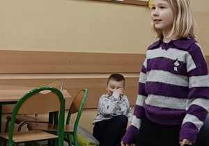 Dziewczynka tańczy na dywanie do muzyki