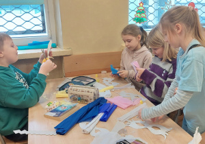 Uczniowie stoją przy stoliku