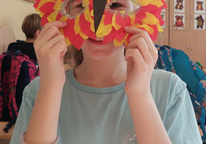 Uczennica pokazuje swoją maskę