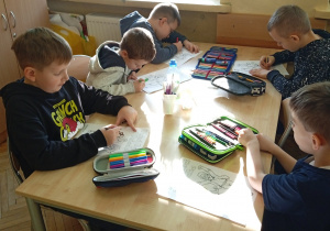 Uczniowie pracują przy stoliku