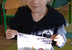 Dziewczynka pokazuje swoją pracę