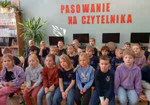 Uczniowie siedzą na krzesłach