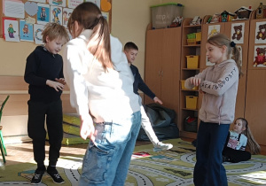 Dzieci prezentują taniec dla babci na dywanie