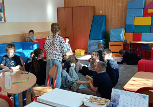 Dzieci pokazują zabawę z dziadkiem na dywanie