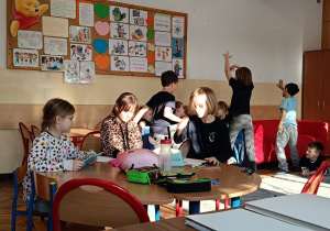 Dzieci pokazują zabawę z dziadkiem