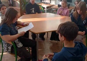 Uczniwie siedzą w bibliotece szkolnej