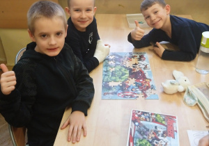 Uczniowie pokazują ułożone puzzle