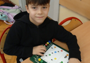 Uczeń siedzi przy stoliku