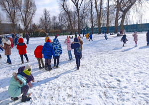 Uczniowie bawią się na śniegu