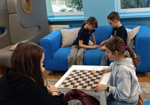 Dzieci grają wspólnie w gry planszowe w kąciku ciszy