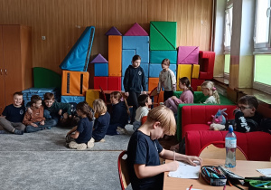 Dzieci wykonują zabawę w grupie na dywanie