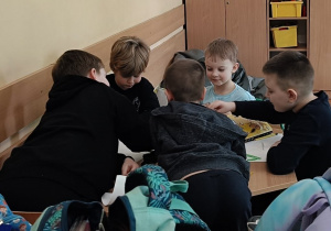 Dzieci kolorują obrazek kota kredkami