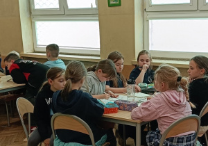 Dzieci wykonują zadanie praktyczne przy stoliku