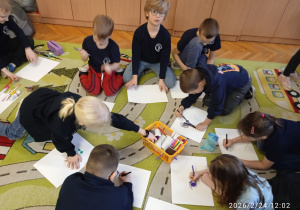 Uczniowie pracują na dywanie