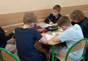 Dzieci wykonują ćwiczenie o dinozaurach na zajęciach świetlicowych