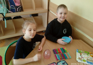 Uczniowie siedzą przy stoliku