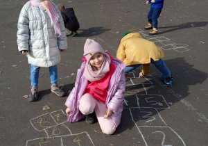 Dzieci rysują kredą na boisku