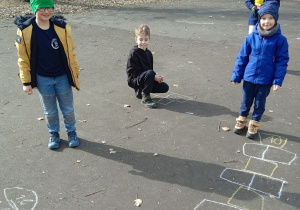 Dzieci rysują kredą na boisku