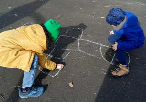 Dzieci rysują kredą na boisku