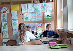 Dzieci pracują przy stoliku wykonując ćwiczenie praktyczne