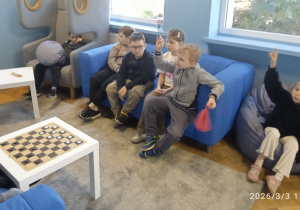 Uczniowie siedzą na kanapach