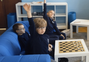 Uczniowie siedzą na kanapach