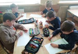 Uczniowie pracują przy stoliku