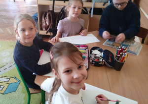 Uczniowie rysują przy stoliku