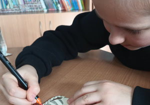 Uczennica koloruje kotka