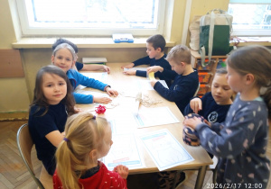 Uczniowie siedzą przt stoliku