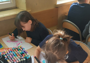 Uczennice malują przy stoliku