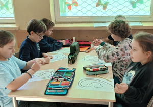 Uczniowie wykonują ćwiczenie praktyczne z szablonem ucha