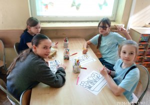 Uczniowie siedzą przy stoliku