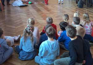 Przedszkolaki siedzą na korytarzu