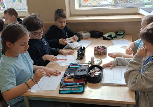 Dzieci wykonują pracę plastyczną na konkurs