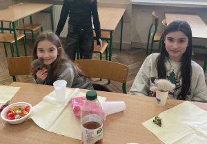 Uczennice siedzą przy stole