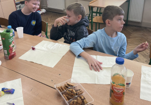 Uczniowie siedzą przy stole