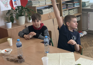 Uczniowie siedzą przy stole