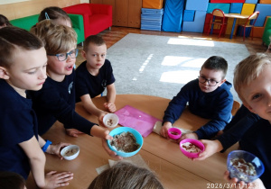 Uczniowie pokazują ziarna rzeżuchy