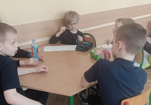 Dzieci naradzają się w grupie podczas ćwiczenia na pomysłowość