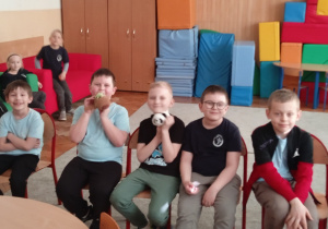 Uczniowie siedzą na krzesełkach