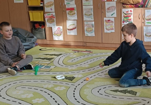 Chłopcy bawią się kreatywnie na dywanie