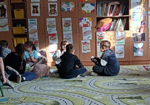 Dzieci w grupie wykonują ćwiczenie ze zmysłem słuchu i wzroku