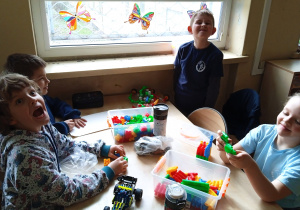 Uczniowie przy stoliku budują z klocków