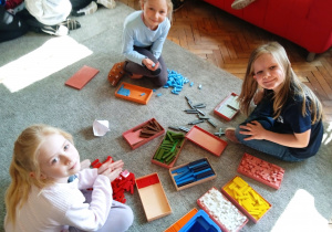 Uczennice bawią się klockami na dywanie