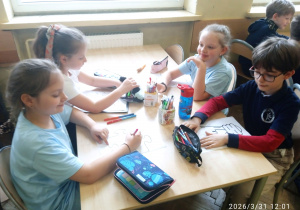 Uczniowie siedzą przy stoliku